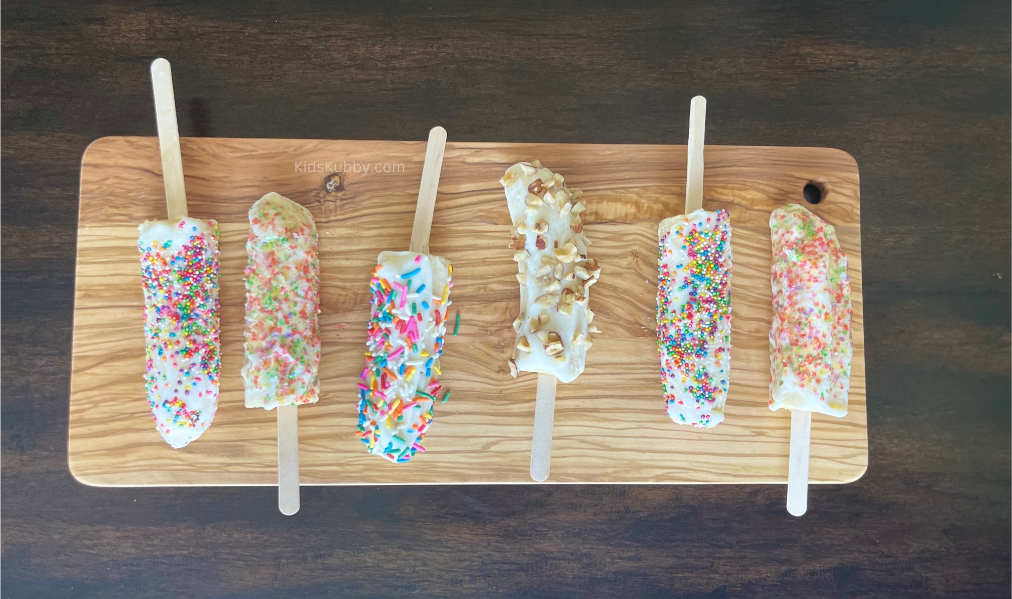 Are you looking for a fun, easy and healthy snack for the kids on a hot summer day? These frozen banana yogurt pops are loaded with nutrients using just a few ingredients bananas, greek yogurt, and optional toppings. The children will love helping you make these delicious treats!