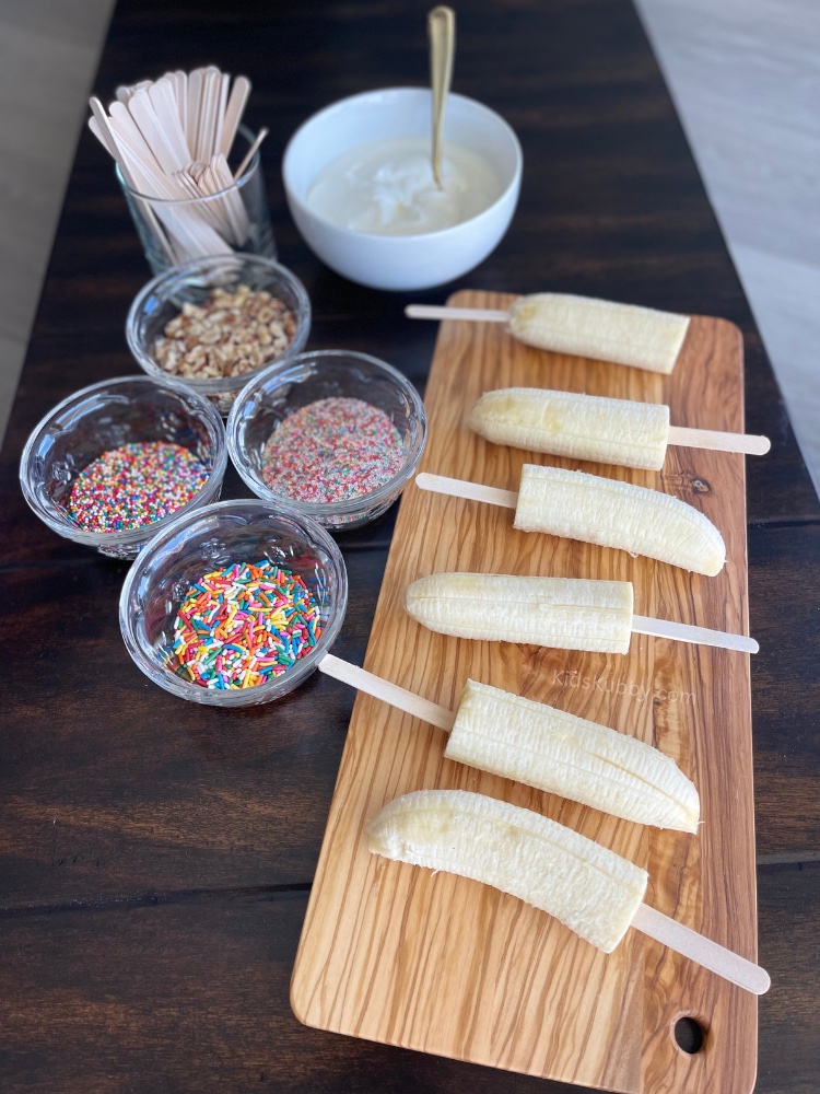 Are you looking for a no-bake snack activity the kids can help you make? The children will have so much fun dipping and decorating their bananas. They make for the perfect snack on a hot summer day at the pool.