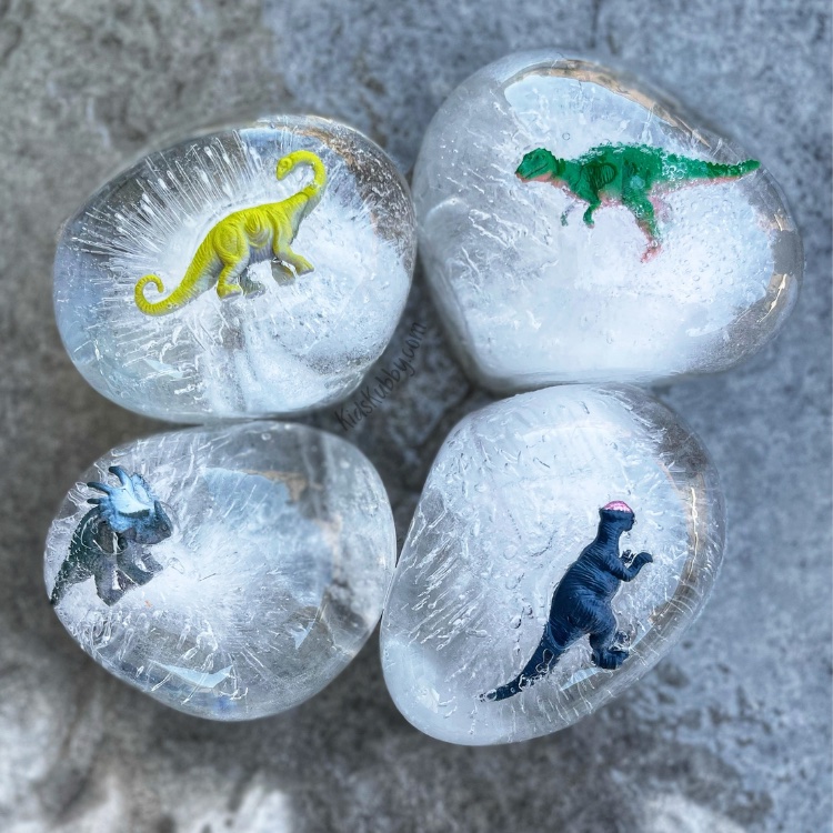 Your kids are going to love frozen dinosaur eggs! This fun outdoor summer activity is sure to keep them busy for hours! When I came across this activity I planned to do it with my toddler but my almost teen even joined in on the fun and he LOVED IT maybe even more than his little brother! It is so easy to create with just few supplies toy dinosaurs, balloons and any tools the kids can use to help bust the dinosaurs out.