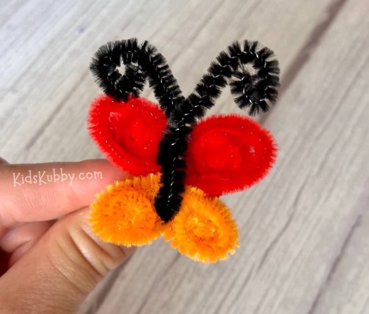 Are you looking for an easy craft to keep kids busy - try making pretty butterfly rings out of pipe cleaners. This low mess craft only takes 5 minutes, but the results are so fun. Make pretty DIY butterfly rings in different color combinations for every finger. You only need 2 ½ pipe cleaners per ring so this is a great cheap craft to make at home!