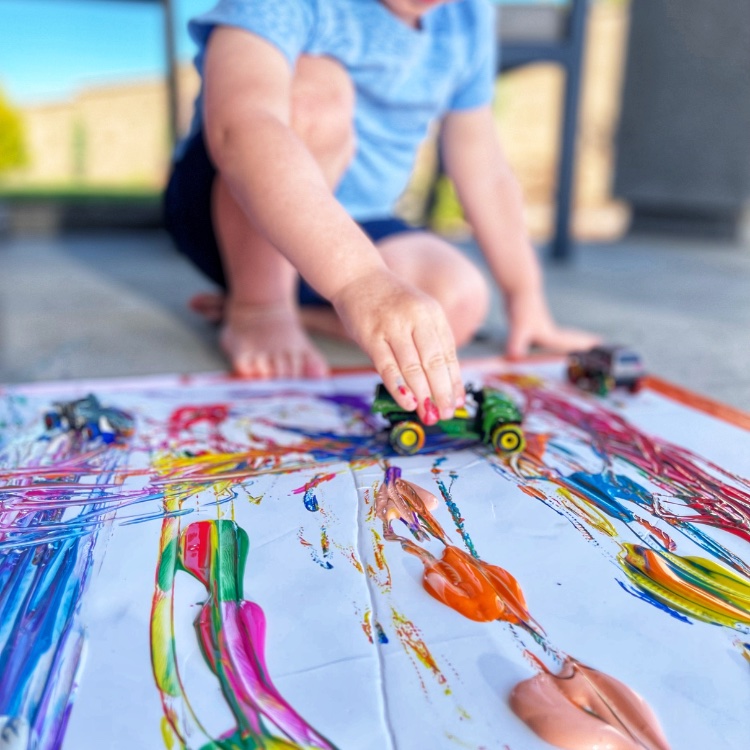 Painting with cars is a fun and easy art activity your kids can do outside. All you need is some paint, paper and toy cars and you are all set. Your kids will absolutely love creating and making their own little master piece.