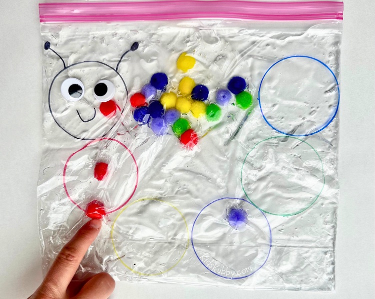 Create your own caterpillar color sorting sensory bag! A fun sensory bag to teach colors and practice fine motor skills. Click the link to get all the details on how to make this easy pom pom sensory bag at home today!