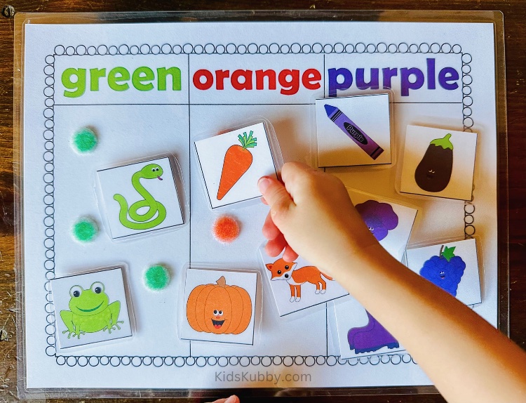 toddler sorting and orange carrot on a laminated color sorting mat. This is an easy way for children to work on color recognition and fine motor skills