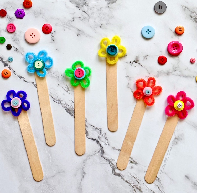 An easy and fun craft for kids of all ages that encourages reading and creativity. I love these DIY popsicle stick flower bookmarks. They are the perfect way to make reading time fun for kids especially with summer reading assignments. Plus, this simple pipe cleaner bookmark takes only 5 minutes to make! Let your kids pick their favorite color buttons and pipe cleaners to really customize their own flower bookmarks. Such an easy art project for kids.