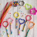 Simple outdoor craft idea for kids using pipe cleaners, beads, and cookie cutters. Kids will love making their very own magical DIY bubble wands. These bubble wands make a great party activity for kids. Try making bubble wands at your next birthday party or family gathering to keep kids entertained outdoors! Don't forget a lot of bubble solution because your kids are going to be blowing bubble for hours with this simple to make bubble wand craft.