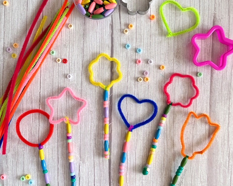 Simple outdoor craft idea for kids using pipe cleaners, beads, and cookie cutters. Kids will love making their very own magical DIY bubble wands. These bubble wands make a great party activity for kids. Try making bubble wands at your next birthday party or family gathering to keep kids entertained outdoors! Don't forget a lot of bubble solution because your kids are going to be blowing bubble for hours with this simple to make bubble wand craft.