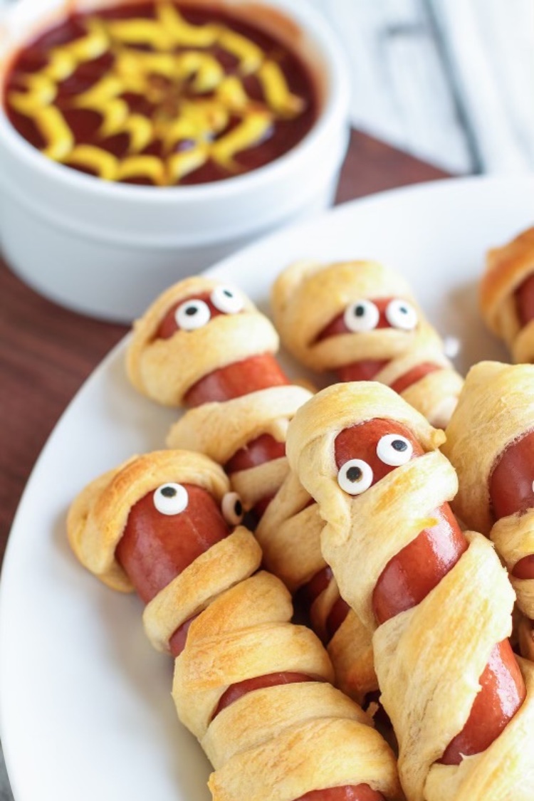 how adorable is this easy halloween recipe. All you need to make the cutest crescent roll mummy dogs are hot dogs, pillsbury crescent roll dough, and some candy eye balls. That's it! in less than 20 minutes you can make this spooky dinner that the whole family will love. Plus kids love to help make this easy recipe!