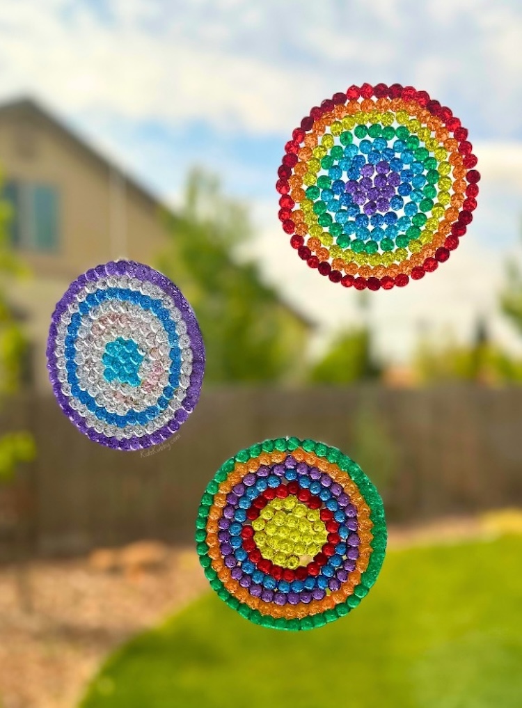Melted bead suncatchers displayed in a window with fishing line and small suction hooks, and fun and easy craft to try at home with kids. 