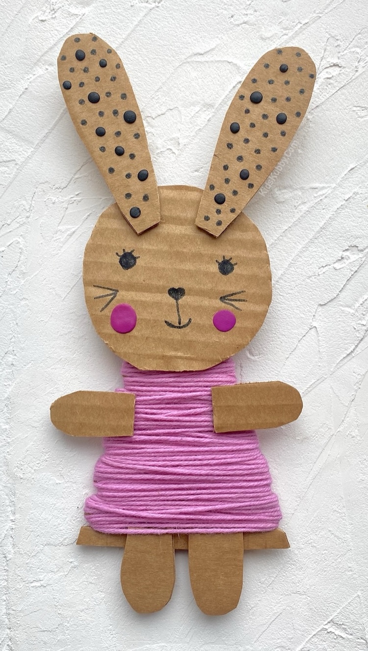 Cheap and recycled bunny craft for kids using colorful yarn and cardboard. An easy and cute project to make at home for spring, Easter, or anytime you want to make something adorable!