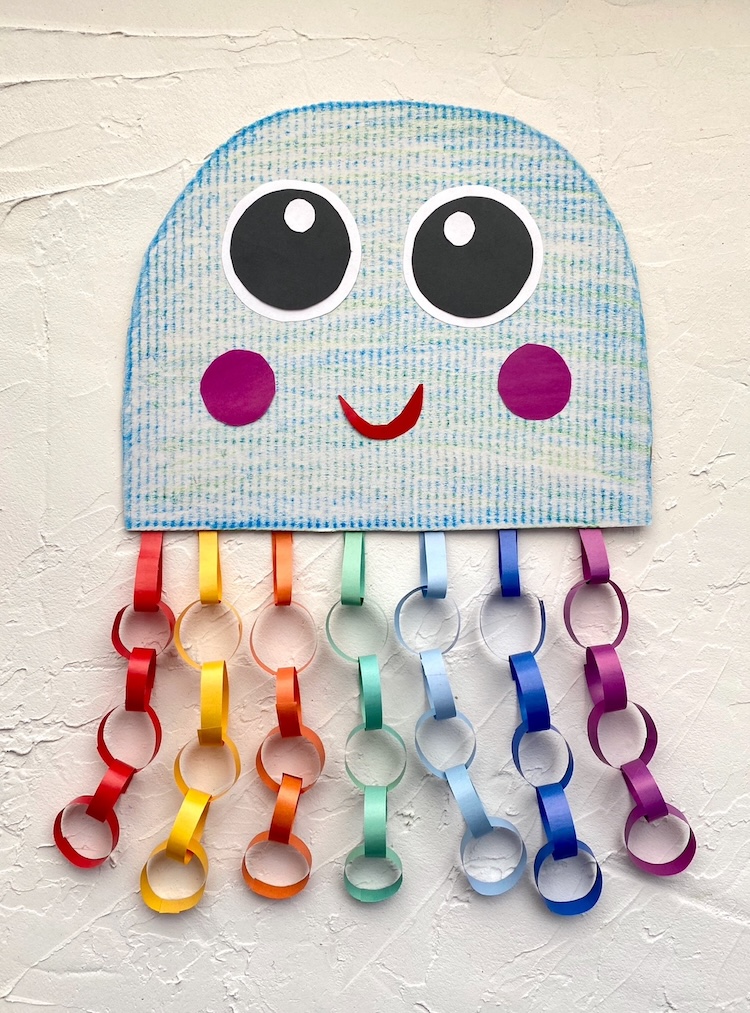 Easy colorful jellyfish craft idea for kids made with constructions paper and recycled cardboard. A fun project to do at home when bored! This ocean themed craft is fun for children of all ages.