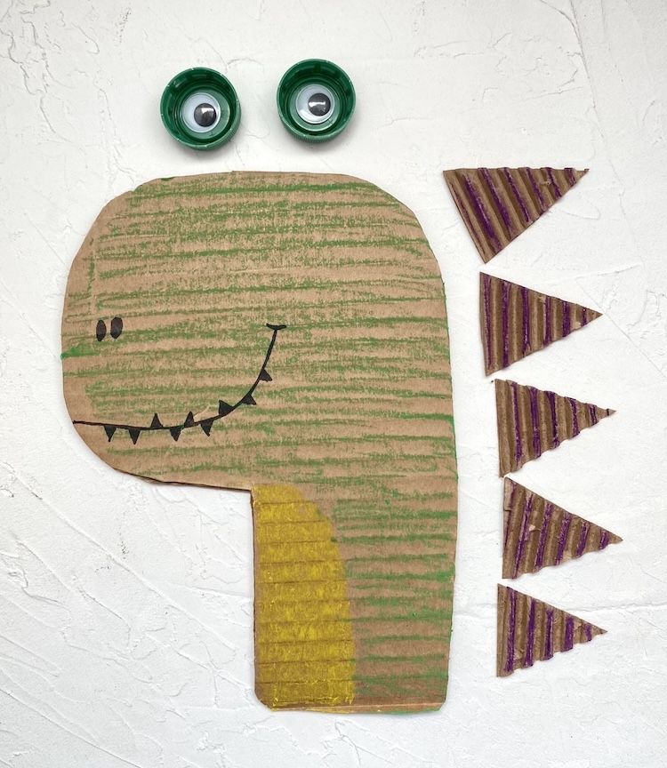 How to make a funny dinosaur craft out of cheap recycled materials you probably have at home: a cardboard box and a few plastic bottle caps. 