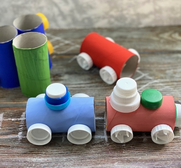 Fun toilet paper roll craft for kids made with cheap recycled materials from home including plastic bottle caps! Step by step tutorial on how to make a cardboard train set.