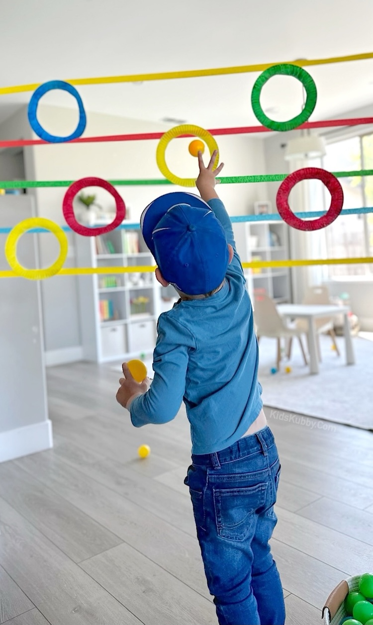 Easy masking tape and paper plate craft to make a fun indoor activity for kids to play. A ball toss challenge!