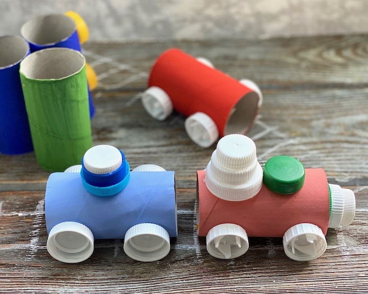 Fun toilet paper roll craft for kids made with cheap recycled materials from home including plastic bottle caps! Step by step tutorial on how to make a cardboard train set.