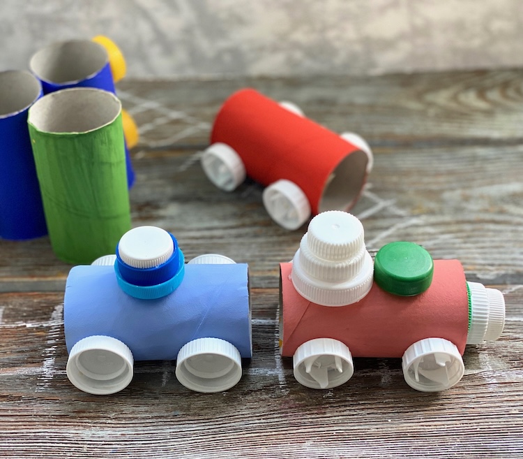 Fun toilet paper roll craft for kids made with cheap recycled materials from home including plastic bottle caps! Step by step tutorial on how to make a cardboard train set.