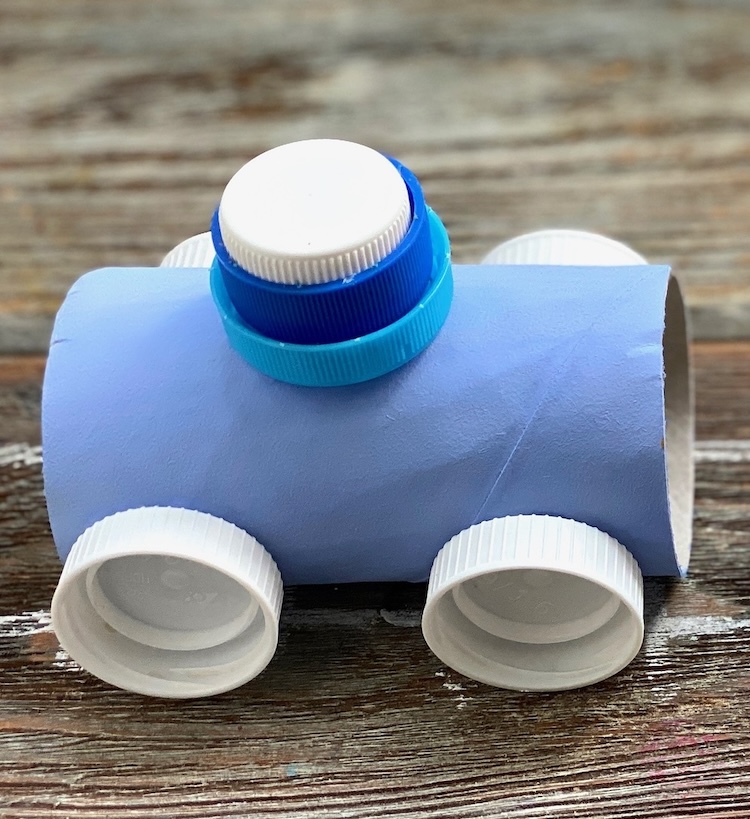 DIY Craft Idea For Kids: Toilet Paper Roll Trains made with a variety of paint colors and plastic bottle caps. 