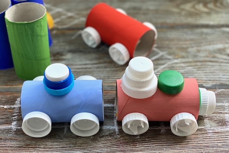How to make cardboard trains with recycled toilet paper rolls, an easy craft idea for kids. My boys loved making these! We used plastic bottle caps for the wheels.
