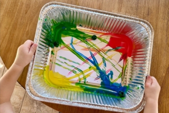 Marble painting is a mess free way for toddlers to paint. Keep all the paint contained in a plastic bin and create unique works of art using marbles.