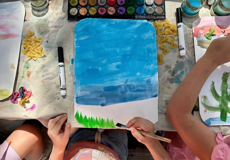 Butterfly art project using uncooked farfalle noodles that look like bowties and some paints. Create a pretty background with paints and then glue butterfly shaped pasta to the paper creating a whimsical springtime scene.