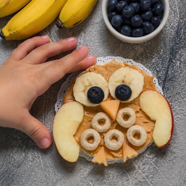 Easy and healthy snack or breakfast idea for kids! How to make adorable owl rice cakes with peanut butter, fruit, and Cheerios cereal.