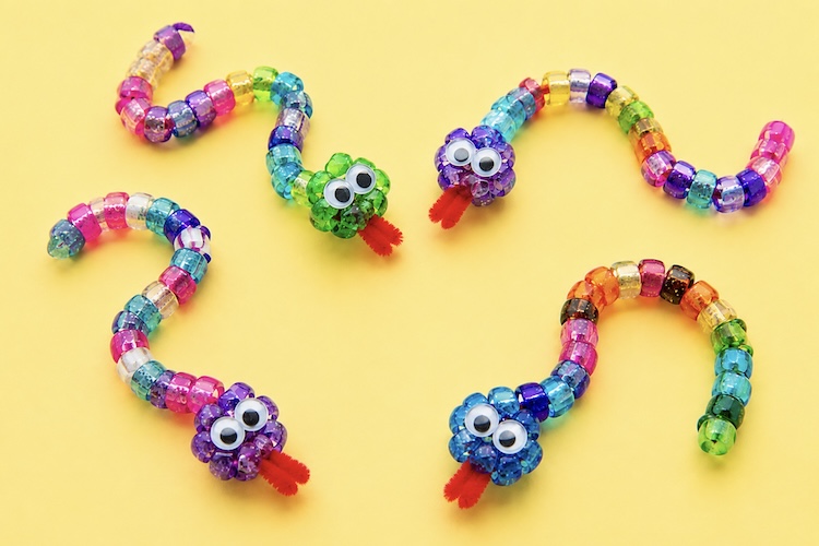 Easy craft for kids making bendable snakes with pipe cleaners and colorful beads. 