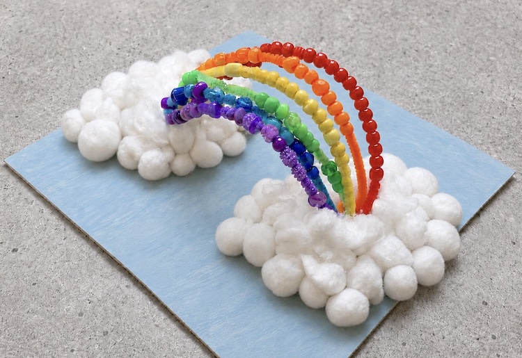 Easy, cheap rainbow craft for kids made with pipe cleaners, pony beads, cotton balls, and cardboard. 