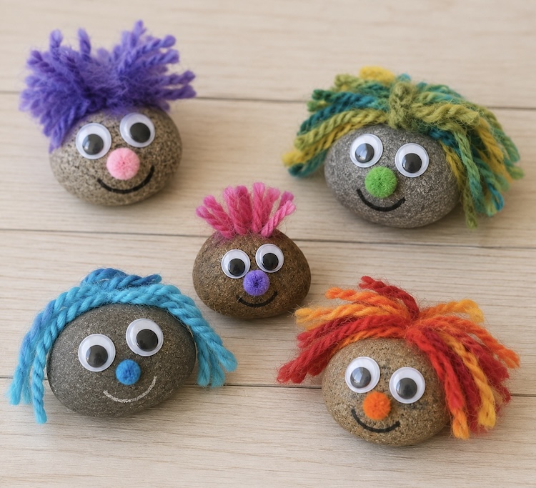 DIY Pet Rocks Craft idea for kids using yarn and googly eyes to make cute faces and fuzzy hair.