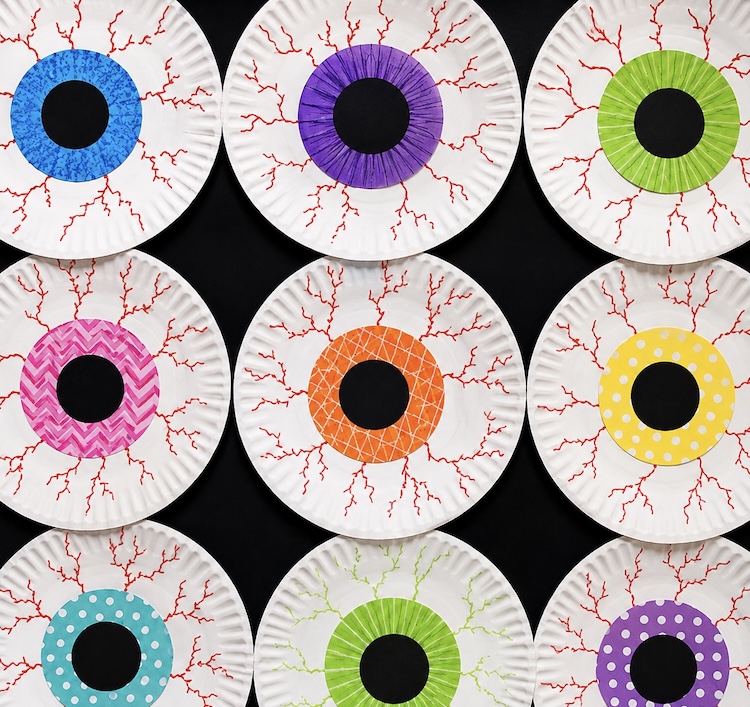 Creepy bloodshot eyeball craft to make for Halloween using white paper plates and muffin tin liners. 