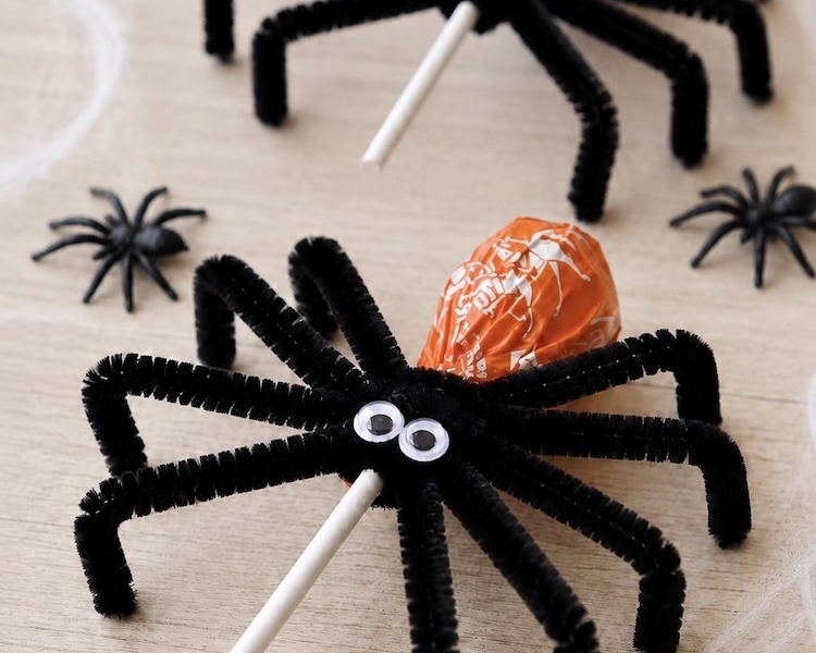 Fun and easy Halloween ideas for kids! How to make DIY lollipop spiders with black pipe cleaners and googly eyes. A fun spooky halloween party favor, decoration, or school treat for the holidays.
