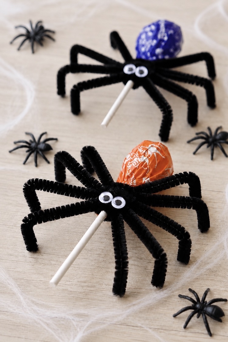 Fun and easy Halloween ideas for kids! How to make DIY lollipop spiders with black pipe cleaners and googly eyes. A fun spooky halloween party favor, decoration, or school treat for the holidays.