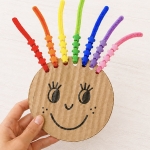 DIY Rainbow Hair Bead Activity to help toddlers and young kids with color recognition and fine motor skills while having fun!