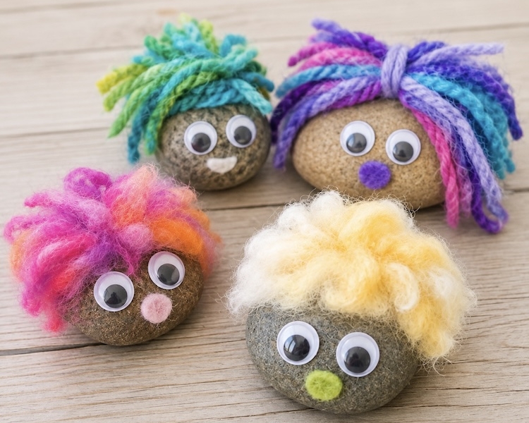 Pet rock ideas for kids with pictures and a fun craft tutorial. These cute fluffy rocks are made with smooth rocks, yarn, felt, and googly eyes.