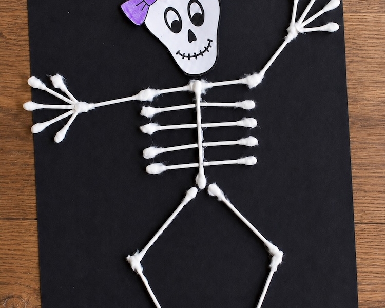 Simple, low mess Halloween craft for preschool age kids. How to make paper skeletons with cotton swabs! A fun and easy art project.