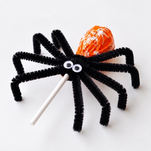 This popular Halloween craft and party treat is a huge hit with kids! Simply wrap a few black pipe cleaners around your favorite lollipops to make candy spiders. They great for fall parties, treat bags, and bringing to school on Halloween.