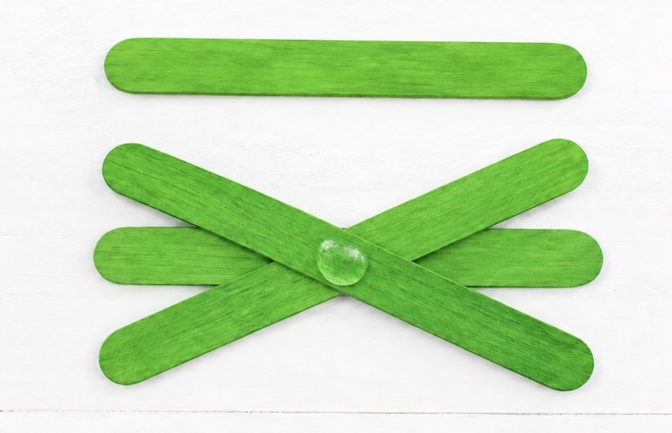 Step by step process of making popsicle stick spiders, a kids craft for halloween that's easy and cheap to make. 