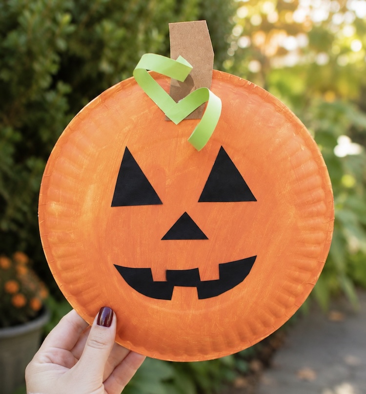 Cute pumpkin jack o lantern craft made with a paper plate and construction paper. 
