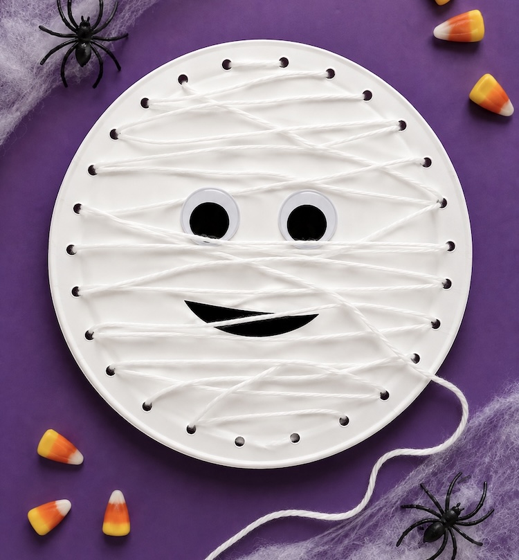 DIY paper plate mummy craft made with white yarn. A fun lacing craft for kids this Halloween. 