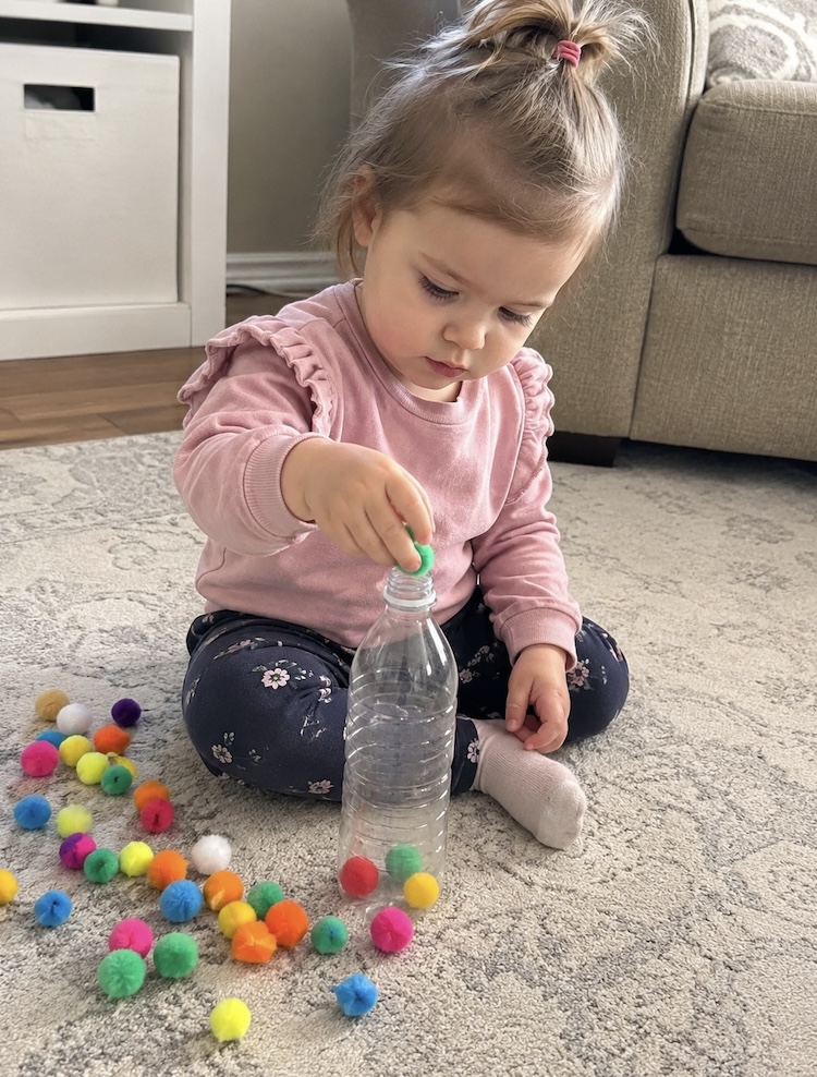Pom pom and recycled water bottle activity for little kids.