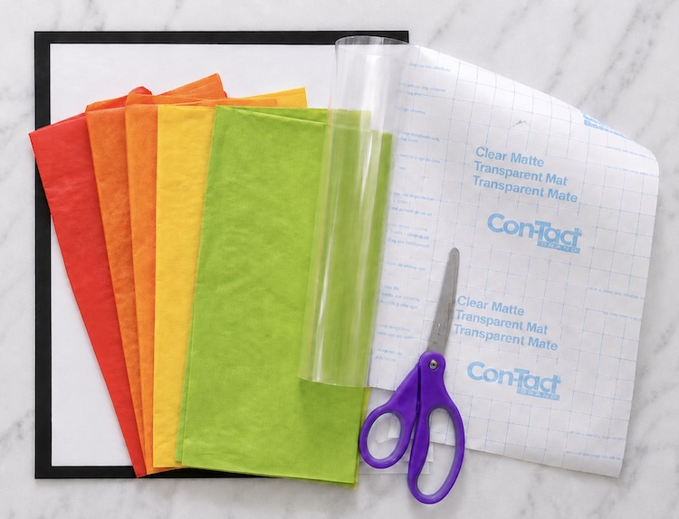 Supplies needed for making DIY Fall Leaf Suncatchers: clear contact paper, black paper, white cardstock, scissors, and colorful tissue paper. Plus the free printable maple leaf template.