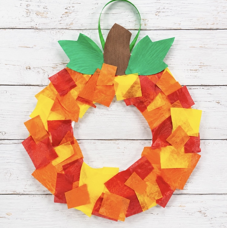 Making a fall paper wreath craft with a paper plate and torn pieces of colorful construction paper. 