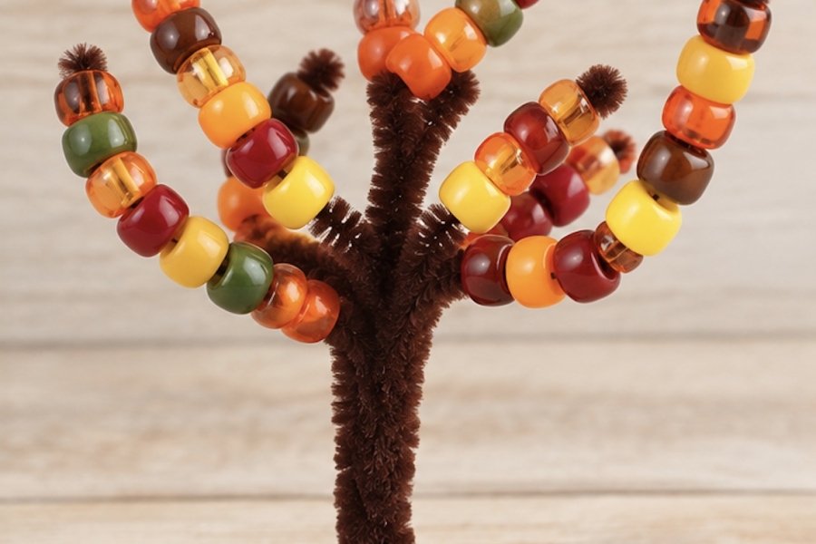 How to make an easy pipe cleaner tree trunk for lacing pony beads onto. A fun learning activity, craft, and fine motor skill practice for young children to practice hand eye coordination and color recognition.