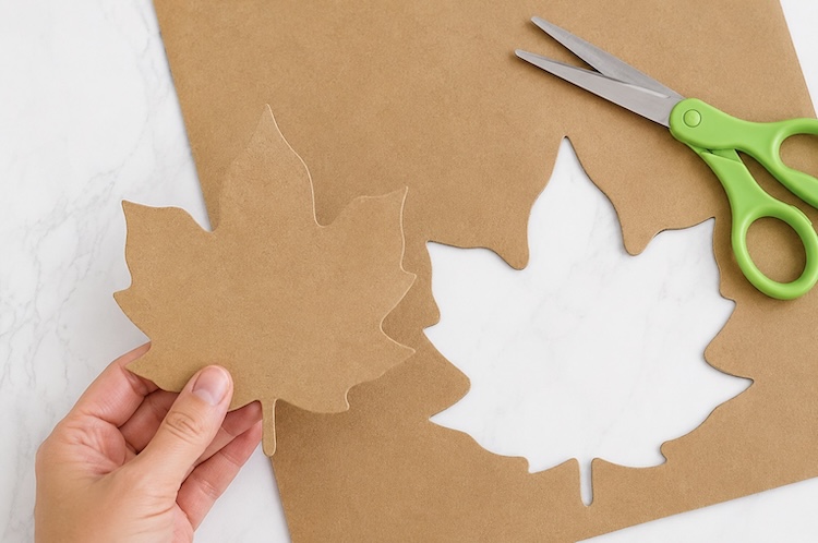 Cardboard leaf cut out of a cereal box for making fun fall leaf mosaics with dried beans. 