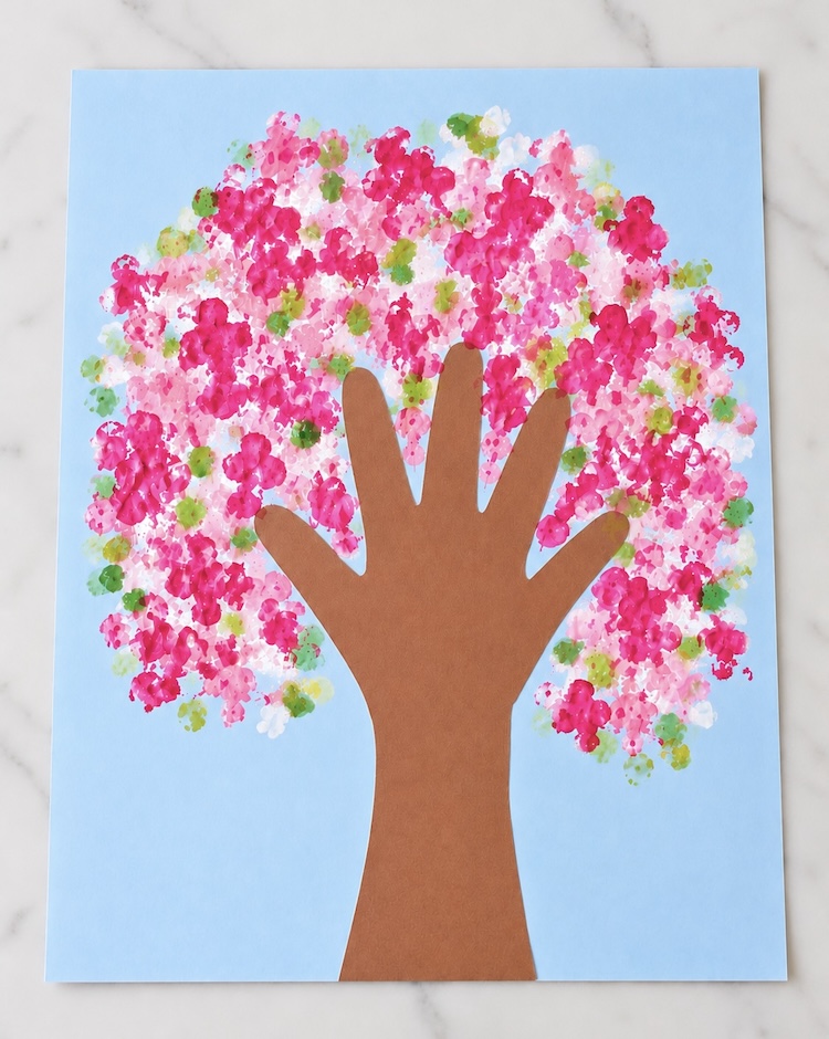 Beautiful DIY Cherry Blossom Spring Tree made with a creative handprint tree trunk and q-tip painted leaves and flowers.