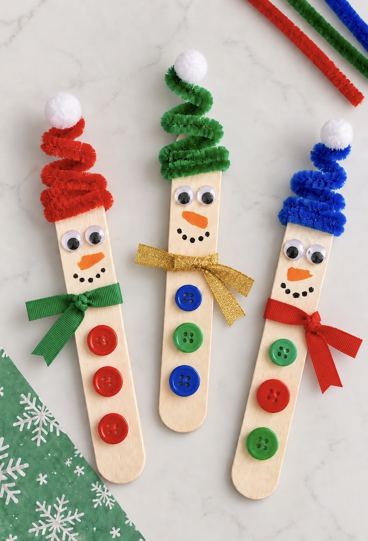 How to make easy DIY popsicle stick snowmen for Christmas! You can hang them in your Christmas tree as an ornament, turn them into a magnet, or simply let the kids play with them.