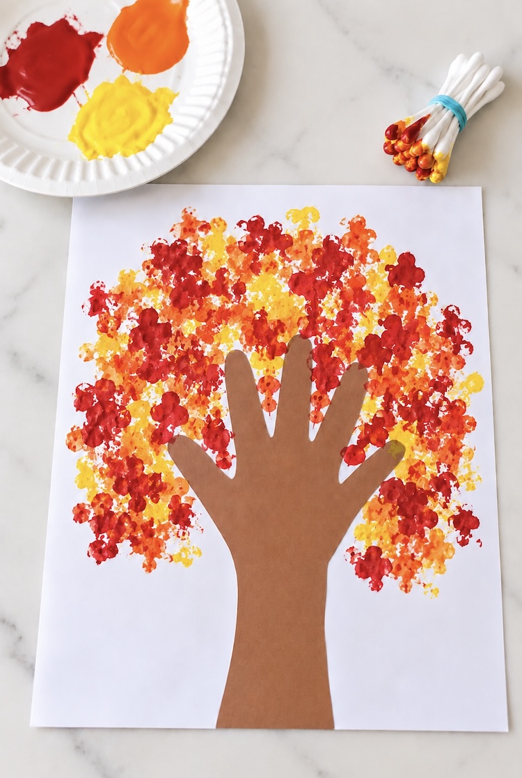 DIY fall tree craft with red, orange, and yellow leaves painted with a bundle of q-tips. An easy arts and crafts project for kids to make in Autumn.