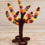 Pipe Cleaner Trees are a DIY activity for preschool kids to do at home by threading pony beads onto the branches to practice fine motor skills and color sorting. A simple craft that can be played with over and over again.