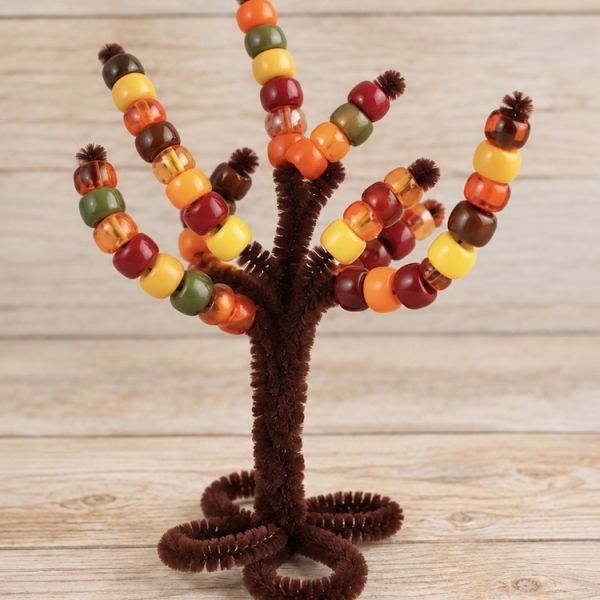 Pipe Cleaner Trees are a DIY activity for preschool kids to do at home by threading pony beads onto the branches to practice fine motor skills and color sorting. A simple craft that can be played with over and over again.