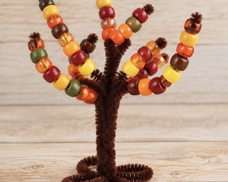 Pipe Cleaner Trees are a DIY activity for preschool kids to do at home by threading pony beads onto the branches to practice fine motor skills and color sorting. A simple craft that can be played with over and over again.