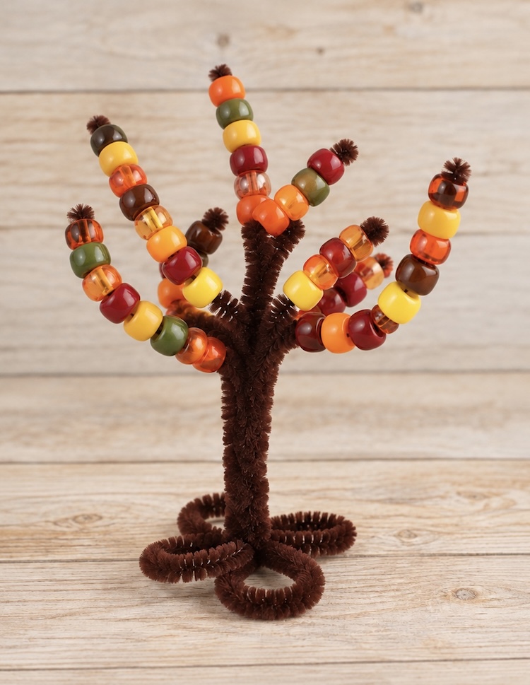 Pipe Cleaner Trees are a DIY activity for preschool kids to do at home by threading pony beads onto the branches to practice fine motor skills and color sorting. A simple craft that can be played with over and over again.