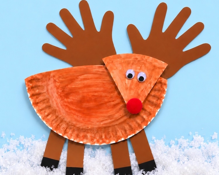 Easy DIY Paper Reindeer Craft For Kids. A simple and fun Christmas craft using handprints for the antlers. Great for preschool age kids to make at home or in the classroom.